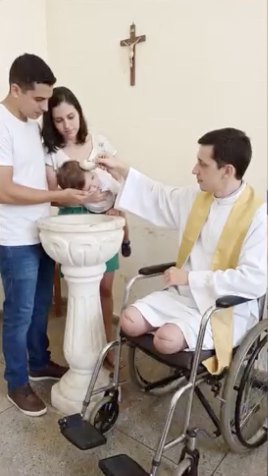 Pastor Michael realizando um batismo sentado em sua cadeira de rodas